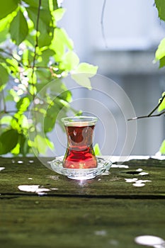 Turkish tea in trasitional glasson wheathered wooden board in a garden