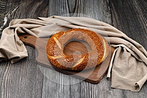 Turkish traditional bagel simit with sesame on rustic table, turkish breakfast pastry concept