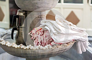 Turkish traditional hammam cotton towels in the interior ancient bathroom with marble fountain