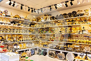 Turkish traditional shop souk with golden decorative tableware.