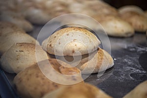 Turkish wheat bread buns lying on a floury dark table
