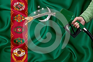 TURKMENISTAN flag Close-up shot on waving background texture with Fuel pump nozzle in hand. The concept of design solutions. 3d