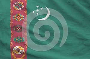 Turkmenistan flag depicted on folded wavy fabric of old cloth photo