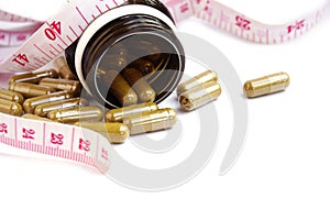 Turmeric capsules and measuring tape isolated on a white background