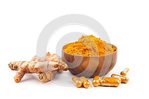 Turmeric capsules and turmeric powder in wooden bowl on white background. Herbal
