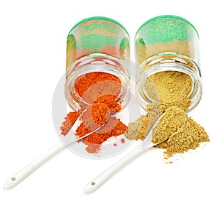 Turmeric and chili pepper powder in glass jar  on white