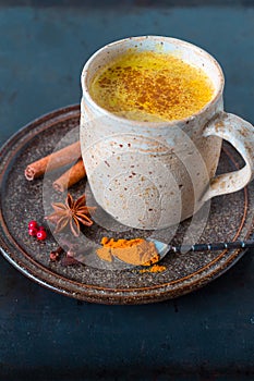 Turmeric golden milk latte with cinnamon sticks