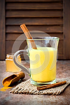 Turmeric golden milk latte with cinnamon sticks and honey. Detox liver fat burner, immune boosting, anti inflammatory drink