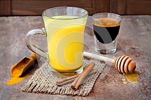 Turmeric golden milk latte with cinnamon sticks and honey. Detox liver fat burner, immune boosting, anti inflammatory drink photo