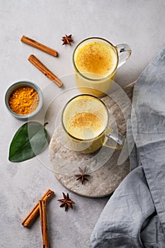 Turmeric golden milk latte with spices and honey. Detox, immunity boosting, anti-inflammatory, healthy, cozy drink in a glass cup