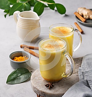 Turmeric golden milk latte with spices and honey. Detox, immunity boosting, anti-inflammatory, healthy, cozy drink in a glass cup