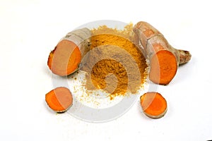 Turmeric powder and fresh turmeric roots isolated on a white background