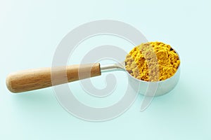 Turmeric powder in a measuring cup