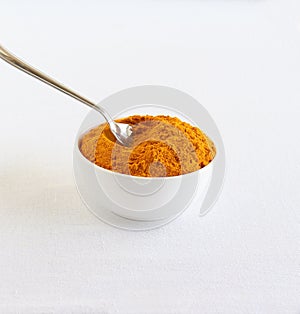 Turmeric Powder Scooped with a Steel Spoon