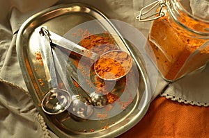 Turmeric powder spice in jar and measuring spoons