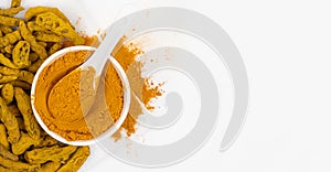 Turmeric powder, spices and dried root on white background. Top view, copy space for text.