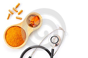 Turmeric powder with tumeric capsules  curcuma, curcumin  and medical stethoscope isolated on white background.