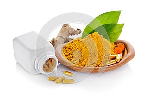 Turmeric powder and turmeric capsules on white background