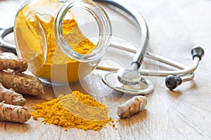 Turmeric powder and turmeric roots with stethoscope, natural medicine