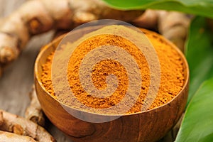 Turmeric powder in wooden bowls on wooden table