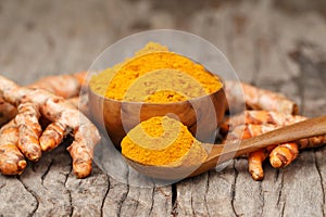 Turmeric powder in wooden bowls on wooden table