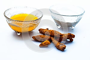 Turmeric & Raw milk face pack isolated on white in a glass bowl along with some raw milk and turmeric present on the surface,Used