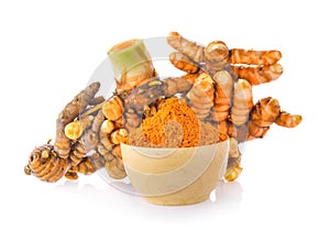 Turmeric root and dry tumeric in wood bowl