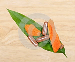 Turmeric Root Powder on wood, Curcuma Root, Turmeric Capsule on Leaf; white background.Herb high vitamin C photo