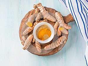 Turmeric spice in powder on wooden board