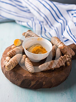 Turmeric spice in powder on wooden board