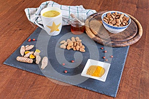 Turmeric tea or golden milk has been venerated since ancient times for its healing properties. Table set with ingredients.