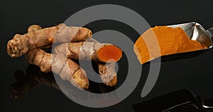 Turmeric, Turmeric Longa, Roots and Powder on Black Background, Indian Spice, Slow Motion