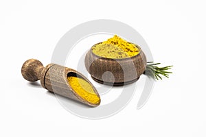 Turmeric in wooden dish, rosemary branch isolated on white background