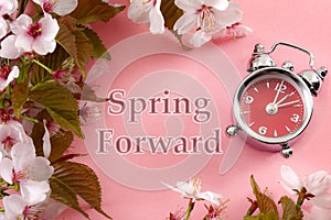 Turn clocks on hour ahead, star of daylight savings time change and reminder to spring forward concept with alarm clock on pink photo