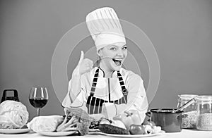 Turn ingredients into delicious meal. Culinary skills. Woman chef wear hat apron near table ingredients. Girl adorable