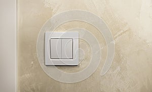 Turn the light on or off. A white light switch on the wall.