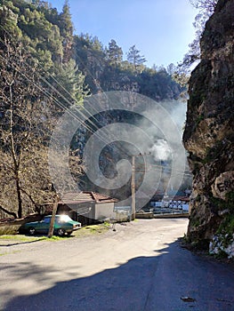 turn mountain road, because of the rocks beautiful view of the house, the car, smoke from pipe home. beautiful landscape