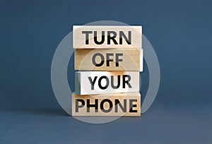 Turn off your phone symbol. Concept words Turn off your phone on wooden blocks. Beautiful grey table grey background. Business,