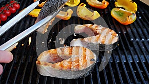 Turn over salmon steak on cast iron grill barbecue. Seafood grill.