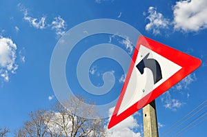 Turn Traffic sign against blue sky with clouds