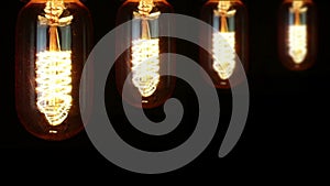 Turn on and turn off in slow motion, four retro vintage light bulb with old technology with filament built-in with warm light