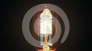 Turn on and turn off in slow motion, retro vintage light bulb with old technology with filament built-in with warm light yellow