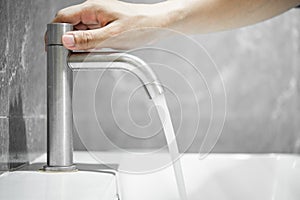 Turn on or Turn off the tap or faucet on a white washbasin.Save water campaign