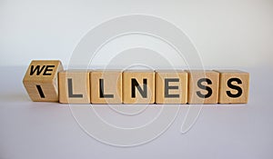 Turned a cube and changed the word `illness` to `wellness`. Beautiful white background. Medical concept. Copy space