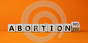 Turned a cubes and changes the expression `abortion yes` to `abortion no` or vice versa. Beautiful orange background. Concept,