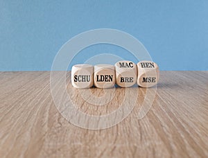 Turned cubes and changes the German expression 'Schuldenbremse' to 'Schulden machen'