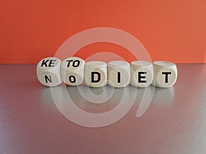 Turned dice and changes the expression No diet to keto diet. Beautiful grey table, red background
