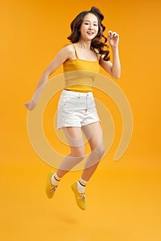 Turned full length body size photo of excited ecstatic beautiful attractive girl isolated over yellow background