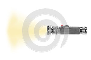 Turned on metal flashlight isolated