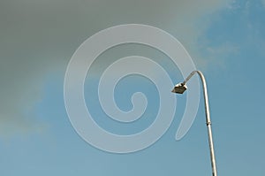 A TURNED OFF STREET LIGHT AND BLACK CLOUD